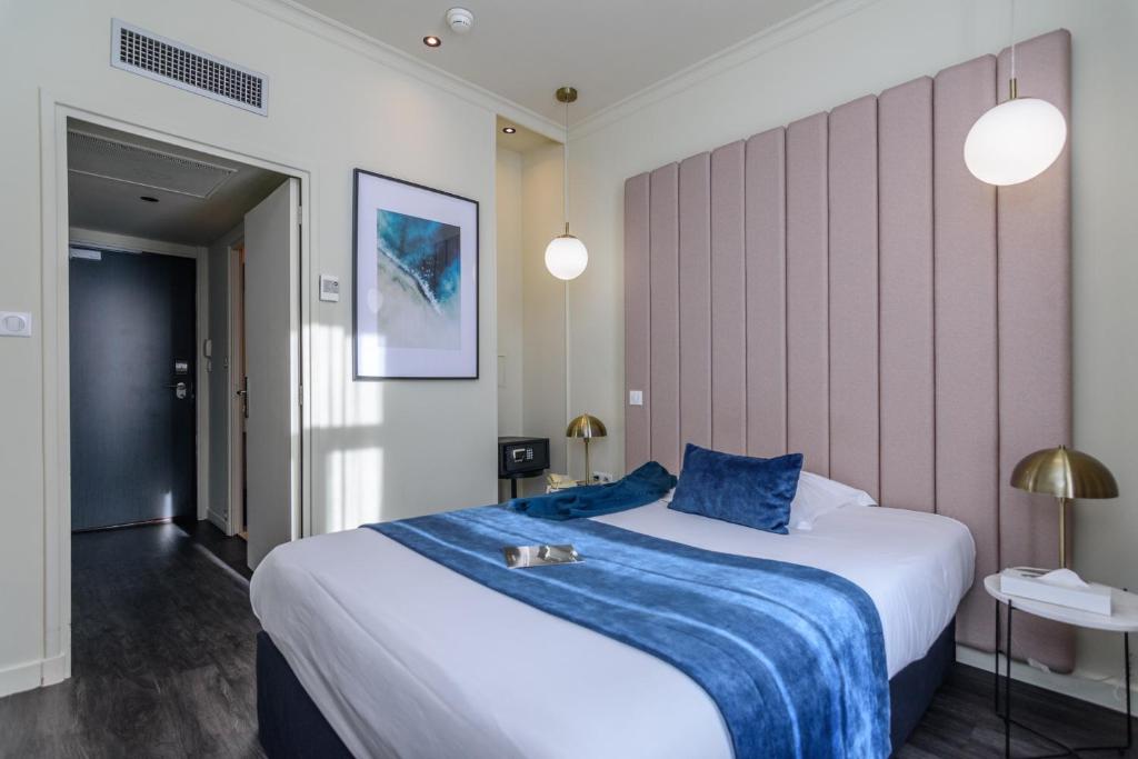 a bedroom with a large bed with a blue blanket at Saint Georges Hotel &amp; Spa in Chalon-sur-Saône