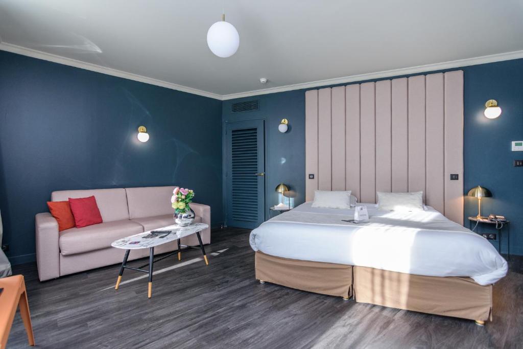 a bedroom with a large bed and a couch at Saint Georges Hotel &amp; Spa in Chalon-sur-Saône