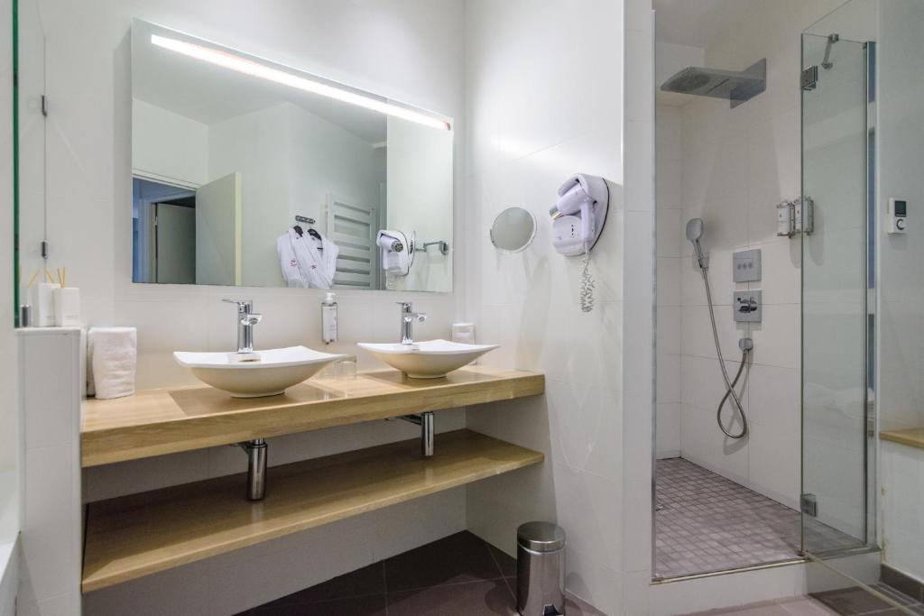 a bathroom with two sinks and a shower at Saint Georges Hotel &amp; Spa in Chalon-sur-Saône