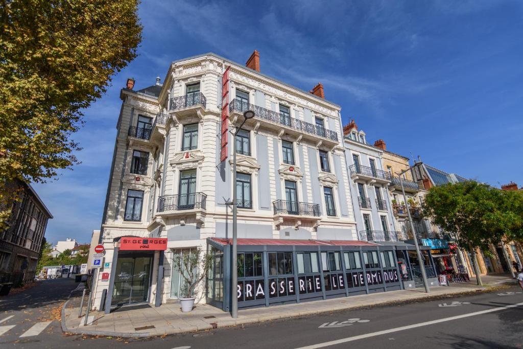 - un grand bâtiment blanc dans une rue de la ville dans l'établissement Saint Georges Hotel & Spa, à Chalon-sur-Saône