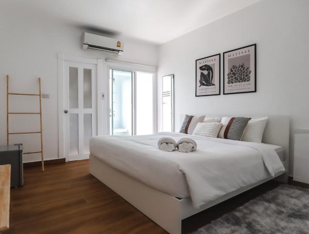 1 dormitorio blanco con 1 cama blanca grande con 2 anillos en Link Mansion en Chiang Mai