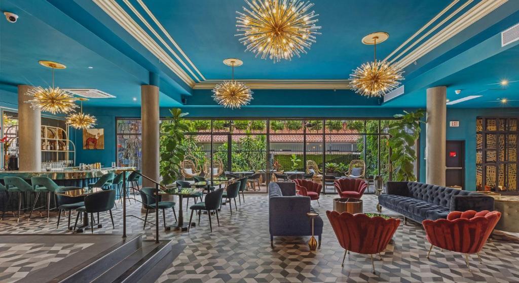 een restaurant met blauwe plafonds en stoelen en tafels bij Don Rafa Boutique Hotel & Residences in San Juan