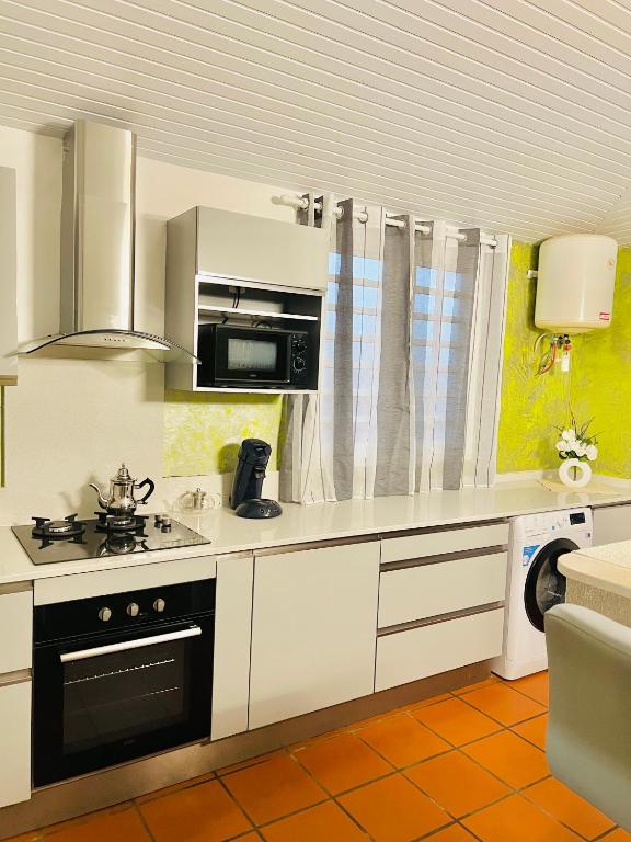 a kitchen with a stove and a microwave at Villa Paradis in Le François