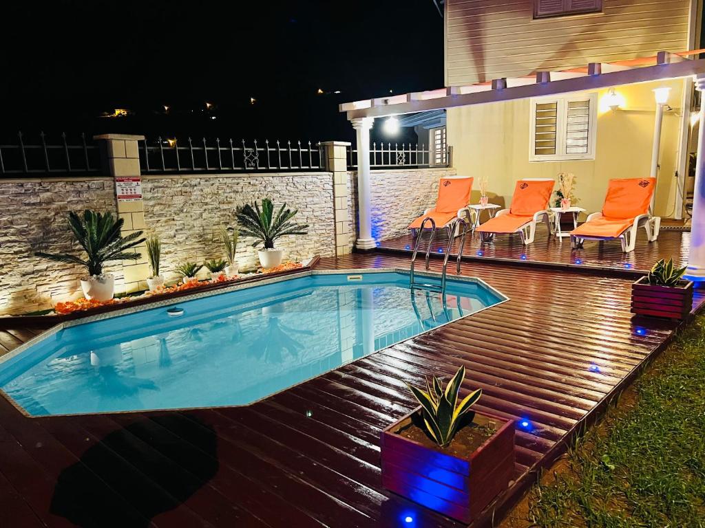 a swimming pool in a backyard at night at Villa Paradis in Le François