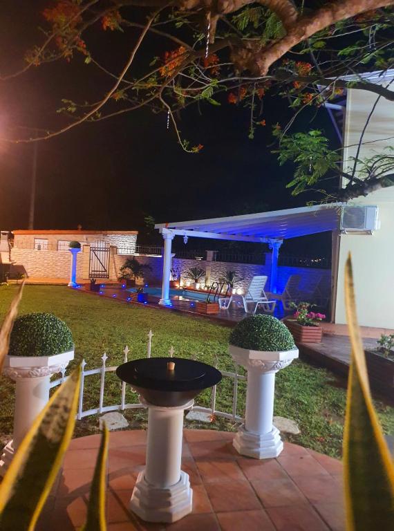 a backyard at night with a table and twoiaries at Villa Paradis in Le François