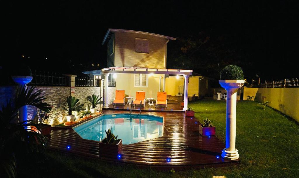 ein Haus mit Pool im Hof in der Nacht in der Unterkunft Villa Paradis in Le François