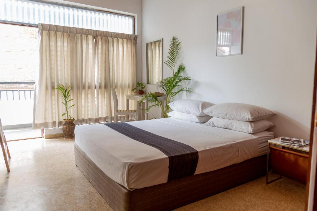 sypialnia z łóżkiem i dużym oknem w obiekcie Greenscape Colombo w Kolombo