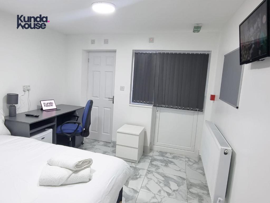 a room with a bed and a desk and a computer at Kunda House Croydon in Birmingham