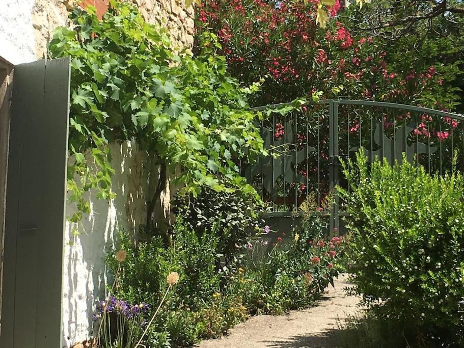 un jardin avec une clôture et des fleurs dans l'établissement L'Ancienne Raffinerie de Tabac, à Dernacueillette