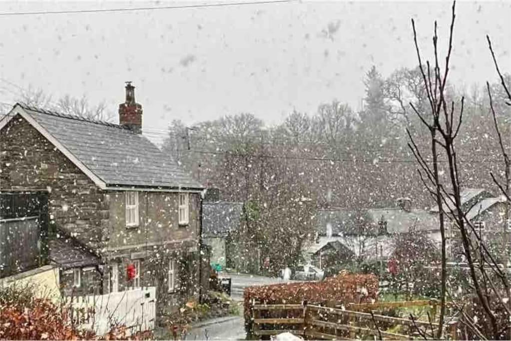 a house in a snow storm in a yard at Isallt Cosy Cottage. Dogs Welcome. Superking & Double Bed. Log Burner. Peaceful Village Location in Llanbrynmair