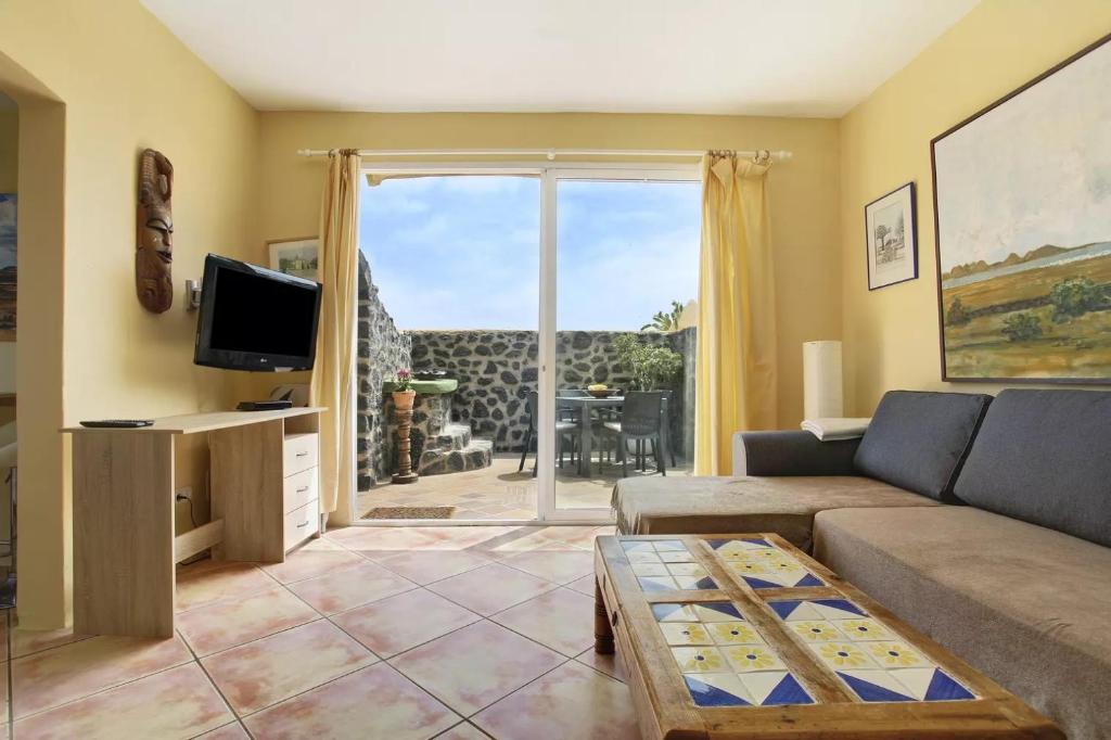 a living room with a couch and a tv at Casa Verde in Teguise