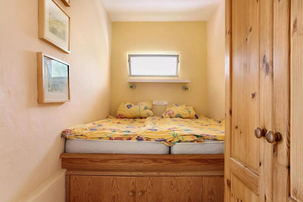 a small bed in a small room with a window at Casa Verde in Teguise