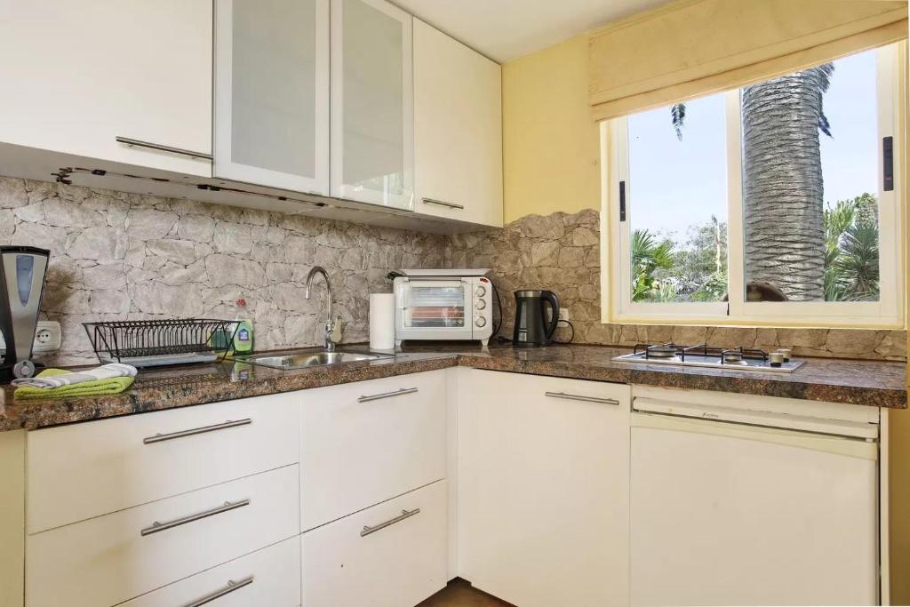 a kitchen with white cabinets and a microwave at Casa Verde in Teguise