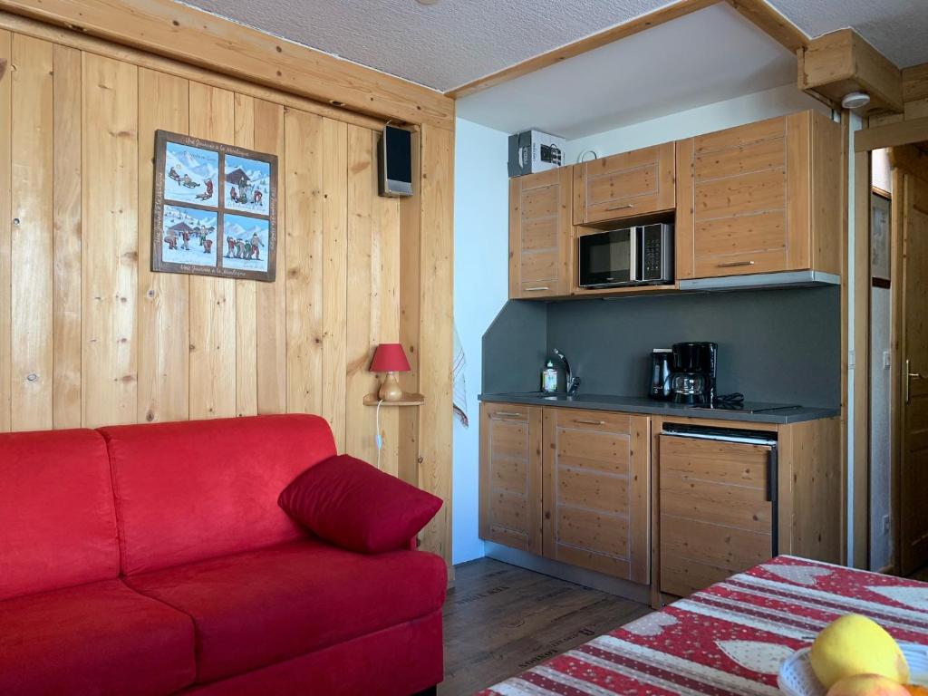 un soggiorno con divano rosso e una cucina di Studio 20 Les Grandes Platières a Tignes