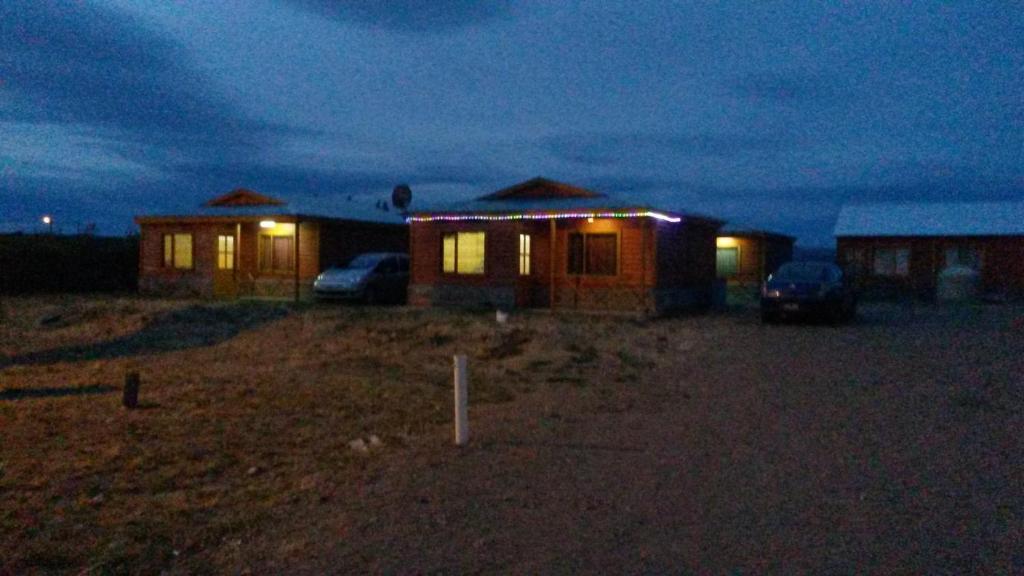 un grupo de casas en un campo por la noche en Cabañas Palo Blanco en Gobernador Costa