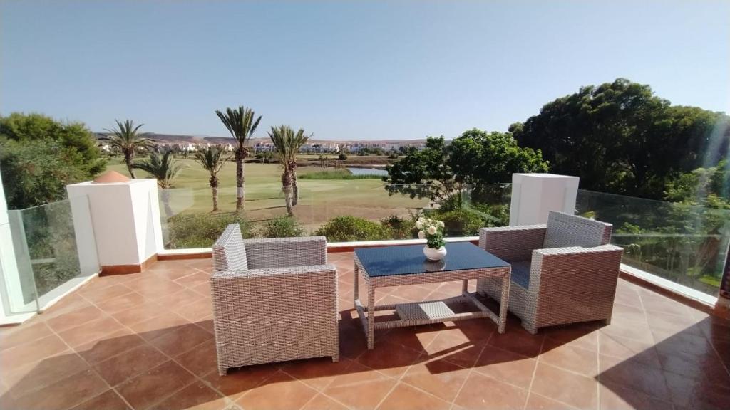 patio con mesa, sillas y vistas en Luxuary Beach Villa Saidia Morocco, en Saidia 