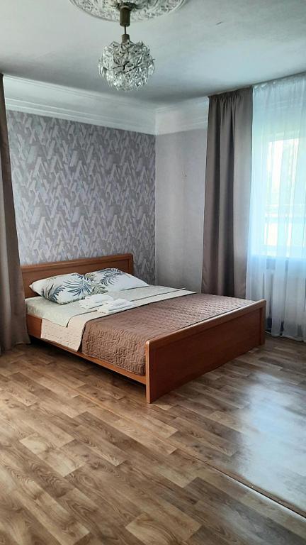 een slaapkamer met een bed en een kroonluchter bij Guest House - Гостевой частный дом in Dnipro
