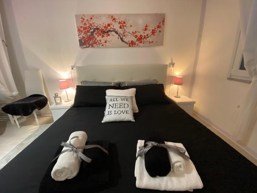 a bedroom with a bed with a black comforter and shoes at Dependance in Tertenìa