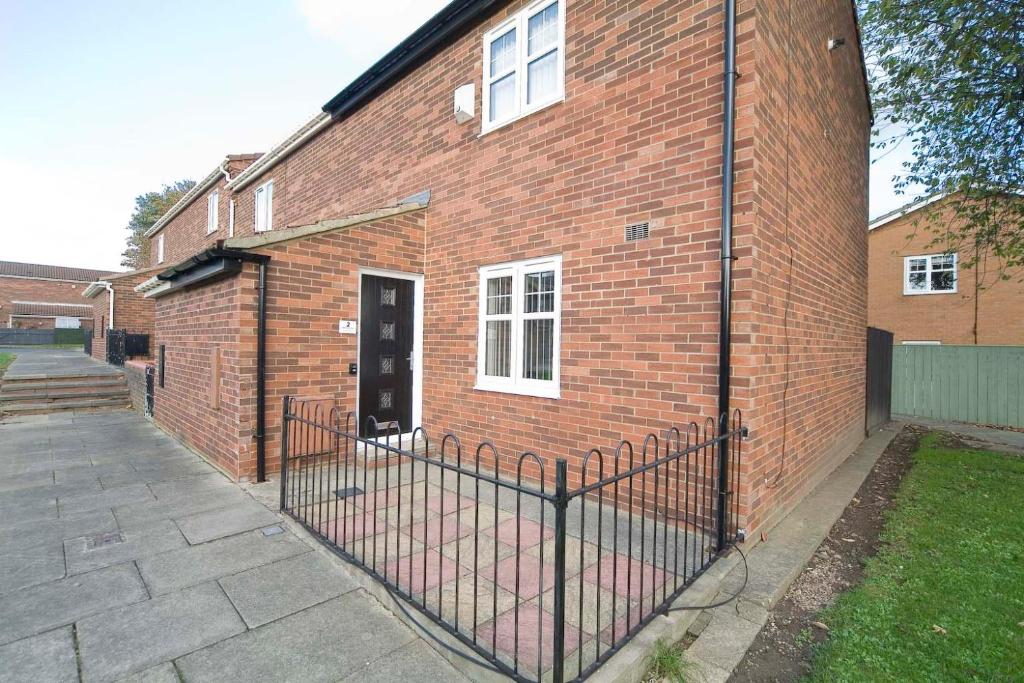 a brick building with a gate in front of it at Marlborough Cottage in Stockton-on-Tees