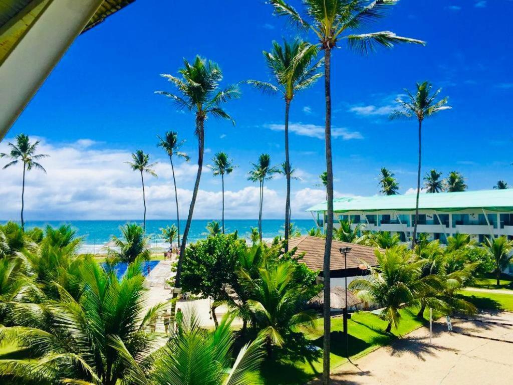 a view of a resort with palm trees and the ocean at Excelente Loft Ancorar in Porto De Galinhas