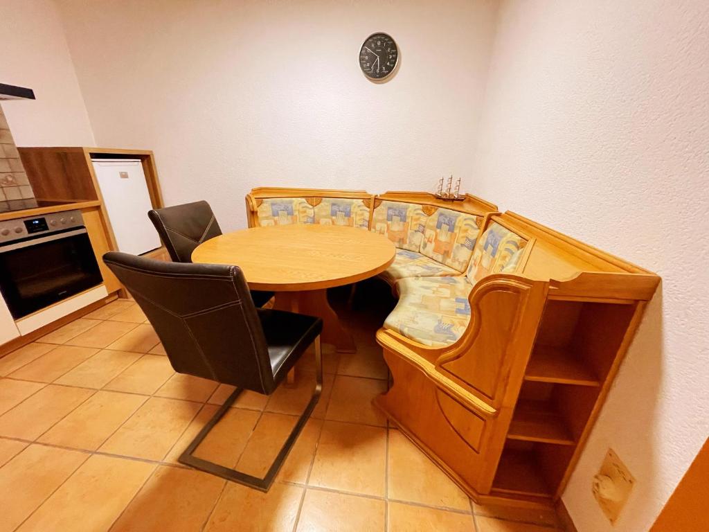 uma sala de jantar com uma mesa de madeira e cadeiras em Frog’s Palace 3 em Altach