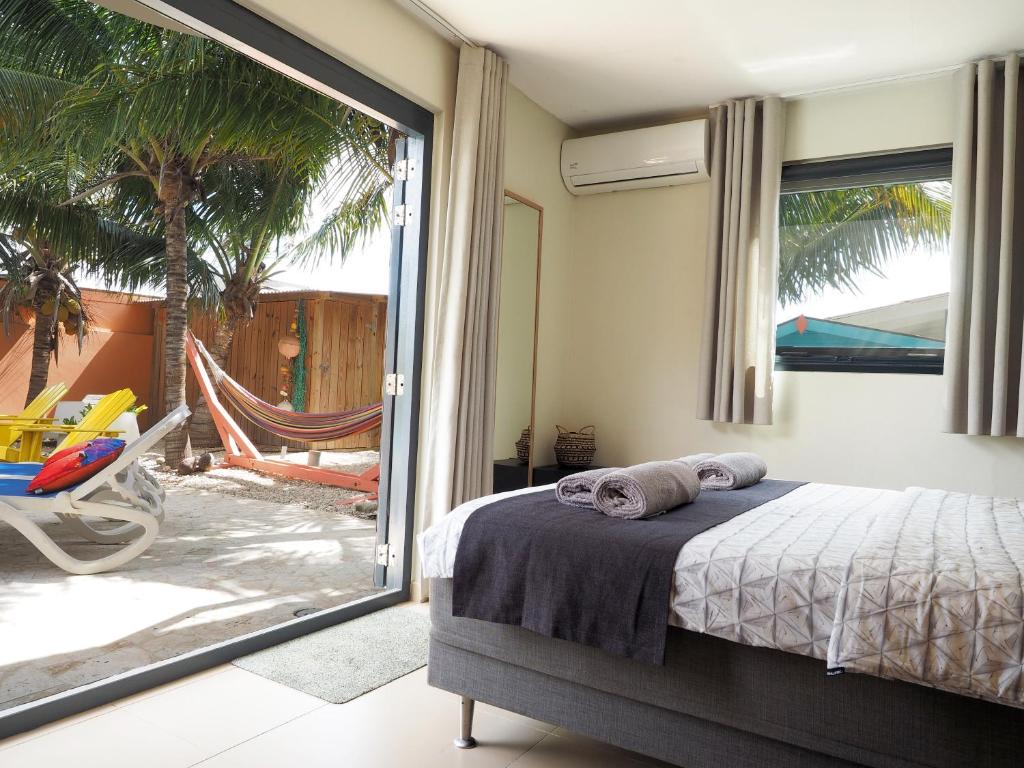 1 dormitorio con 1 cama y puerta corredera de cristal en Oasis guesthouse, Boutique Style Hotel en Kralendijk