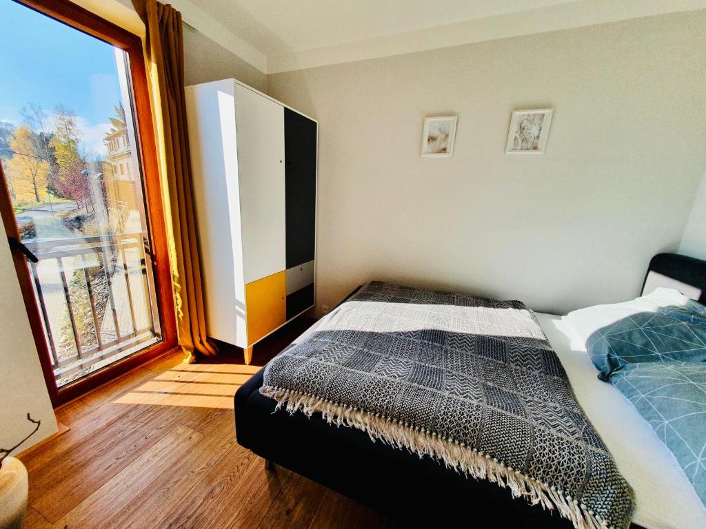 Postel nebo postele na pokoji v ubytování Útulný apartmán v srdci Krkonoš se saunou
