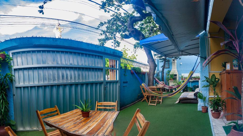 a patio with a table and chairs and a swing at Hostel Dragão do Mar Fortaleza in Fortaleza