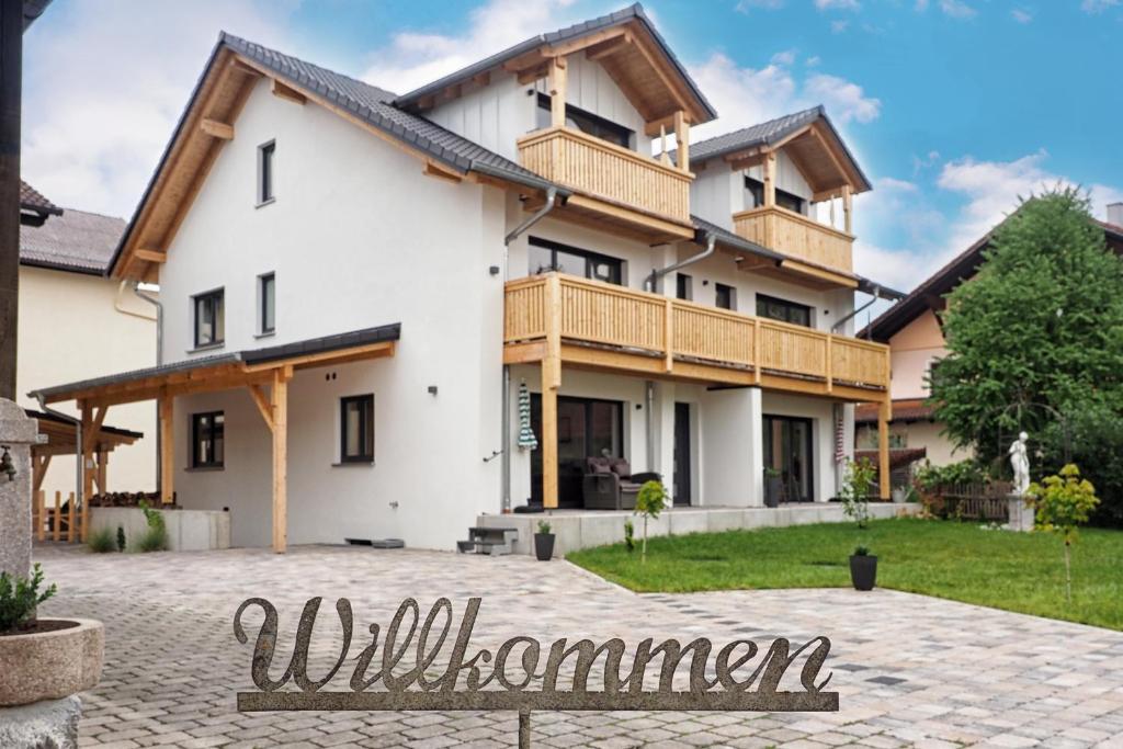 a house with a welcoming sign in front of it at Haus Tobias in Bad Füssing