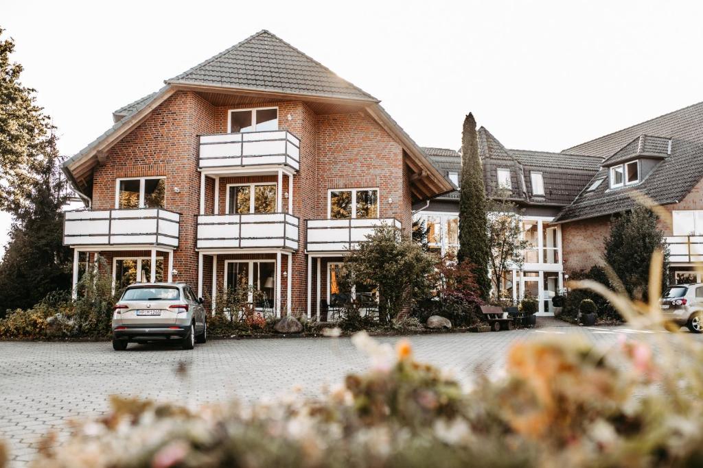 a house with a car parked in front of it at Akzent Hotel Zur Grünen Eiche in Bispingen