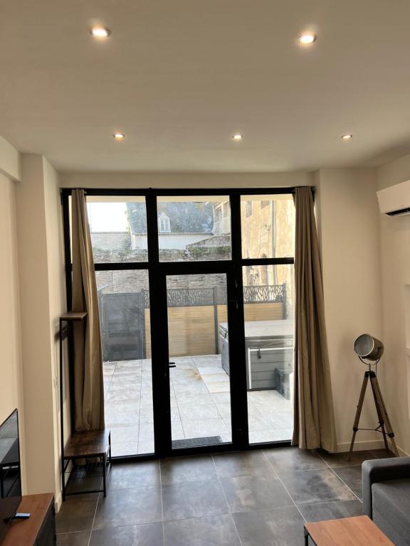 Le Loft Jacuzzi في بلورميل: غرفة معيشة مع باب زجاجي منزلق كبير