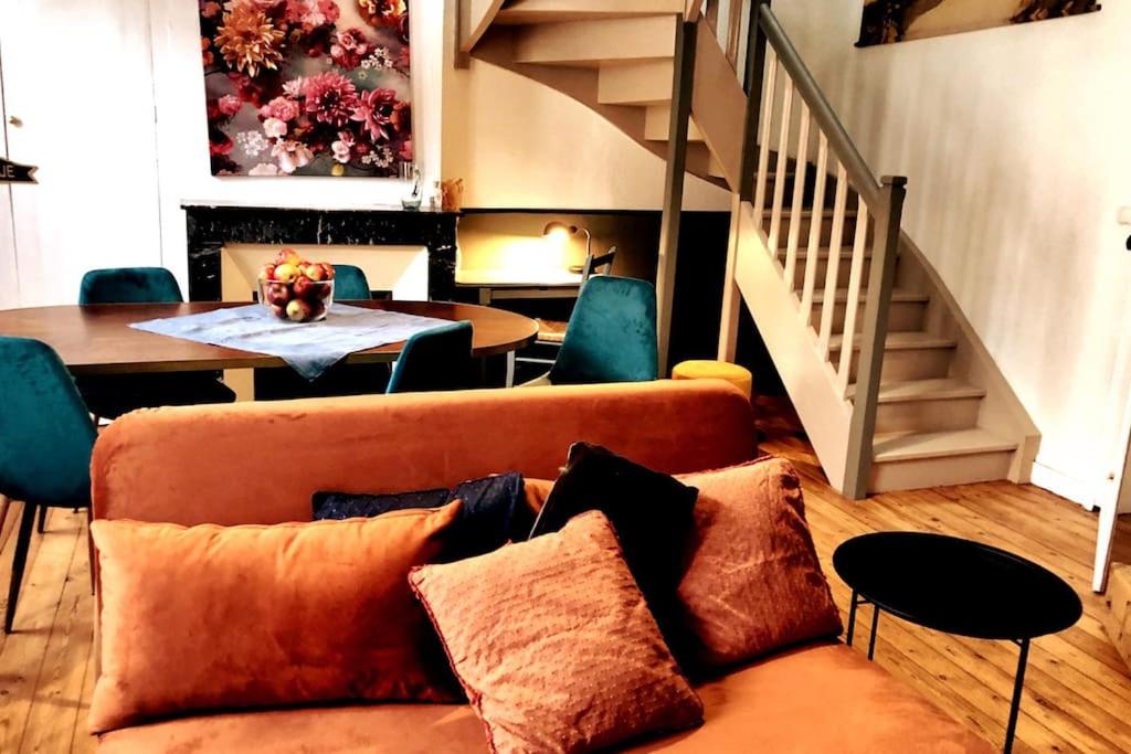 a living room with a couch and a table at NATIFRIENDLY-Appartement centre historique avec jardin IDEAL FAMILLE in Bellême