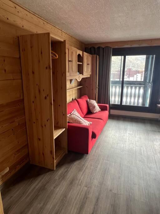 - un salon avec un canapé rouge et une fenêtre dans l'établissement Glaciers / 4 persons apartment, à Val Thorens