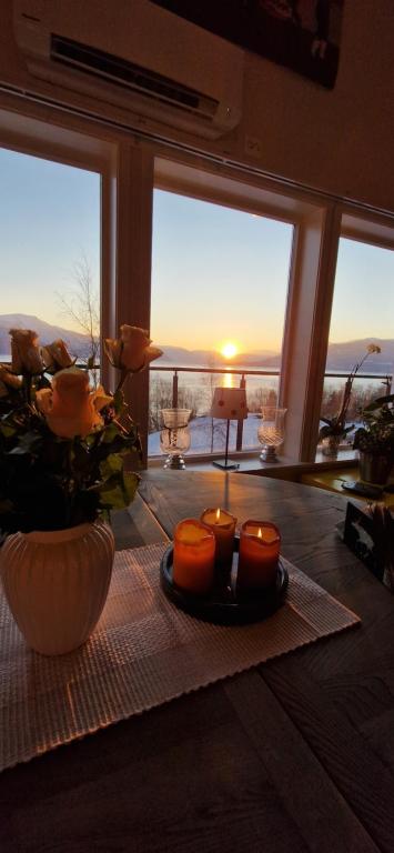 a table with candles and flowers on a table with a view at Frydenlund in Balestrand