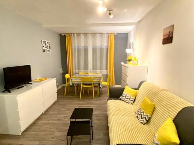 a living room with a yellow couch and a table at Résidence Consuegra in Pas de la Casa