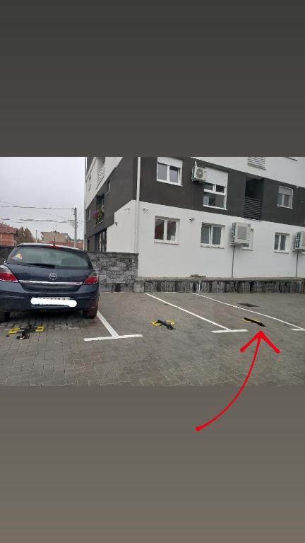 a car parked in a parking lot with a red arrow at Twins Apartments in Čačak