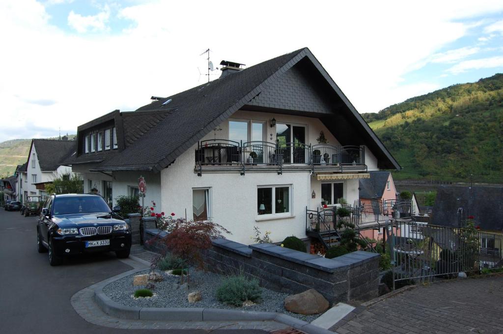 a car parked in front of a white house at Ferienwohnung Konen in Sankt Aldegund