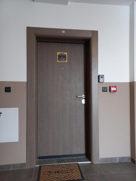 a door in a building with a sign on it at Twins Apartments in Čačak