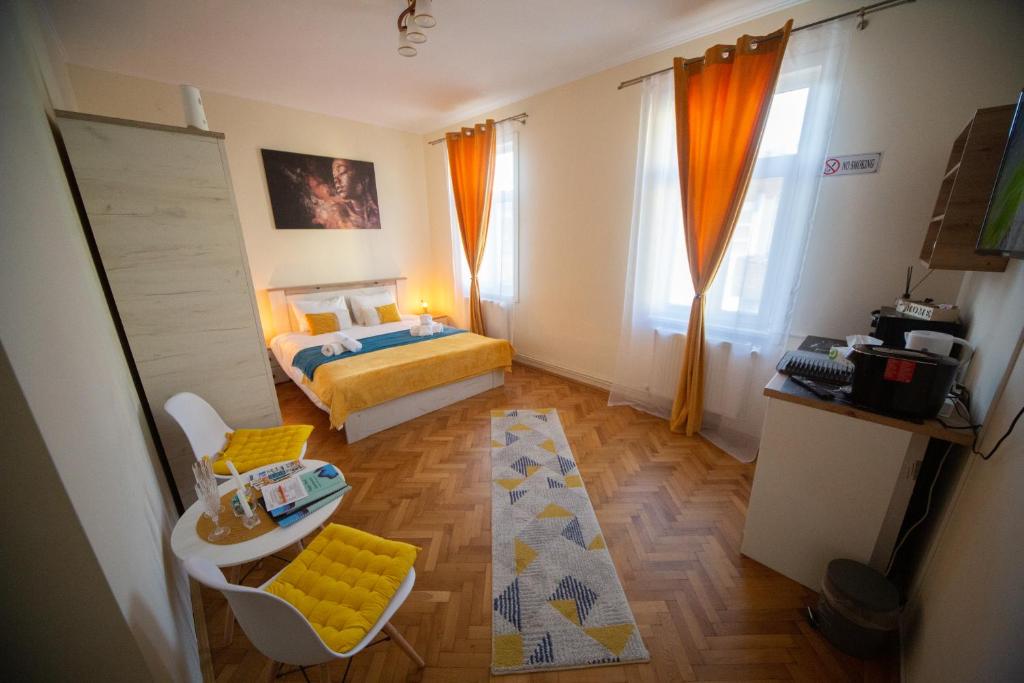 mały pokój z łóżkiem i stołem w obiekcie Happy Mood Apartments w Braszowie