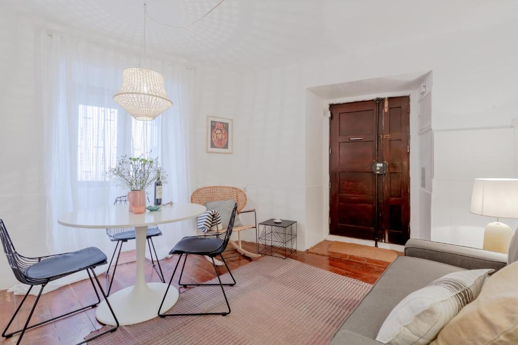 sala de estar con mesa, sillas y sofá en Typical Alfama Apartment, by TimeCooler en Lisboa