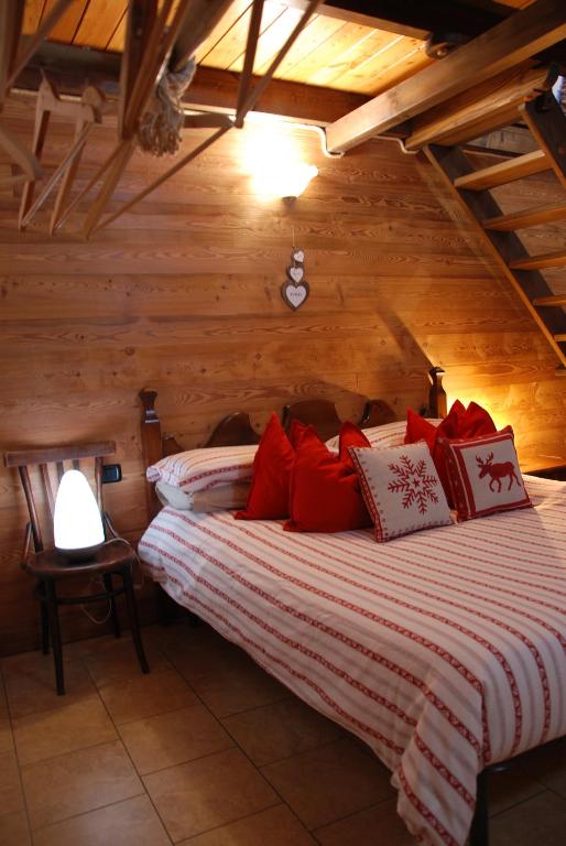 sypialnia z łóżkiem z czerwonymi poduszkami w obiekcie Maisonette w mieście Nus