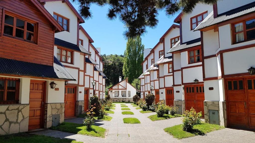 une rangée de maisons avec un trottoir devant dans l'établissement Cabaña Camalen, à San Martín de los Andes
