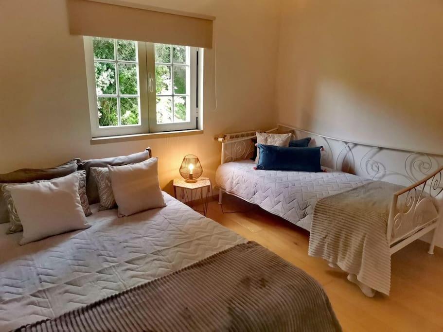um quarto com 2 camas e uma janela em Enjoy Beloura! em Sintra