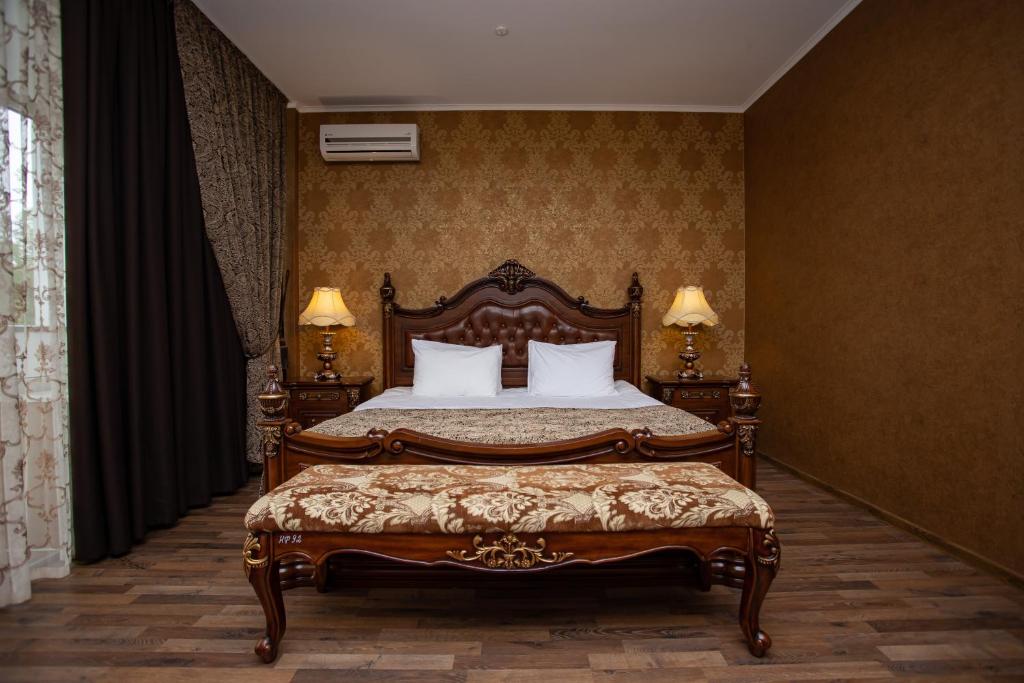 a bedroom with a bed and two lamps on the wall at Perlyna Resort in Cherkasy