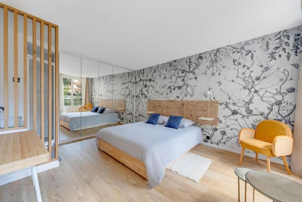- une chambre avec un lit et un mur recouvert de papier peint dans l'établissement A place to chill, à Paris