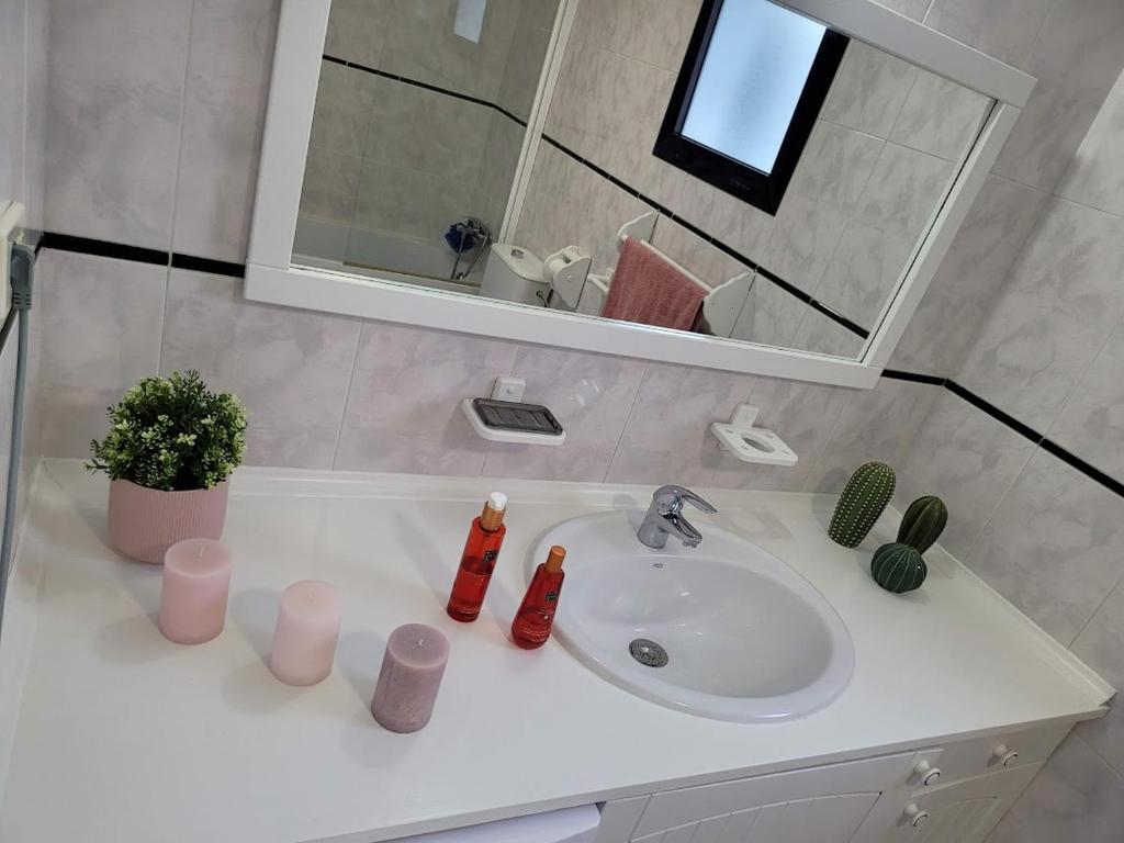 een witte wastafel in een badkamer met een spiegel bij ALLINSEA LA GARITA in La Garita