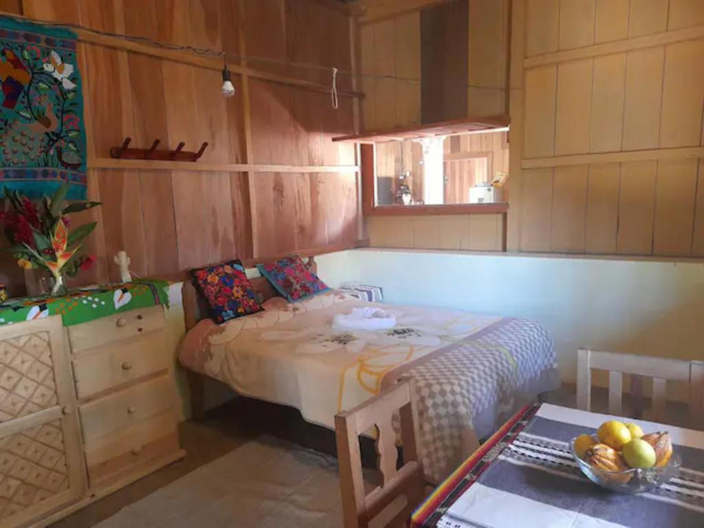 Finca Vista Hermosa - Room in Main House في Pluma Hidalgo: غرفة نوم بسرير وطاولة مع صحن من الفواكه