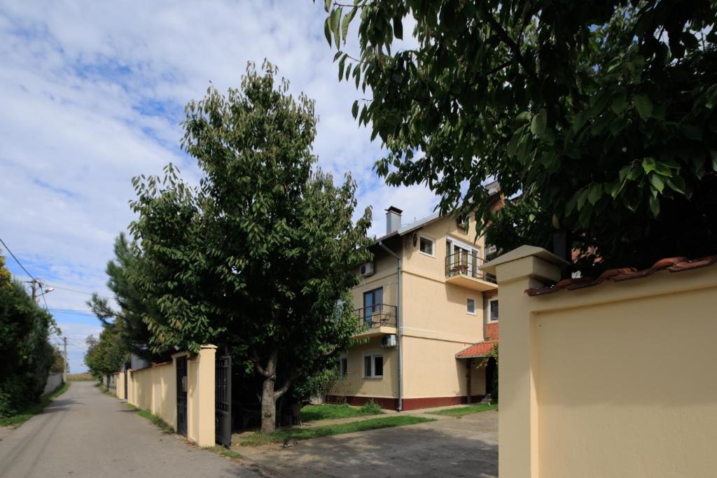 een huis aan de kant van een straat met bomen bij AVIATOR APARTMENTS NIKOLA TESLA Belgrade in Surčin