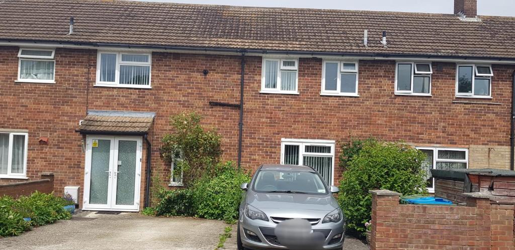 a car parked in front of a brick house at Homely Home in Buckinghamshire