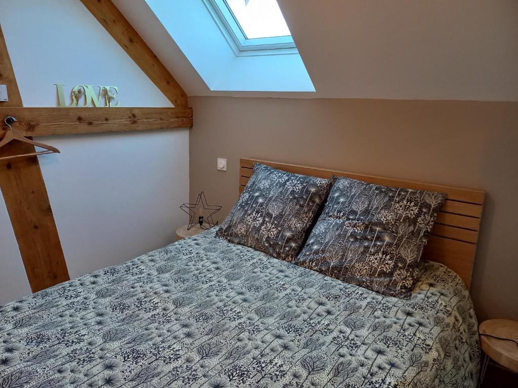 een slaapkamer met een bed en een dakraam bij Séjour à la campagne - Logement cosy et chaleureux in Courgains